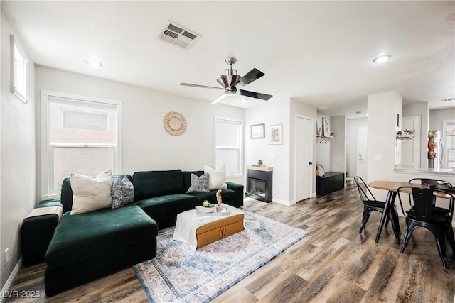 living room with wood finished floors, baseboards, a ceiling fan, and recessed lighting