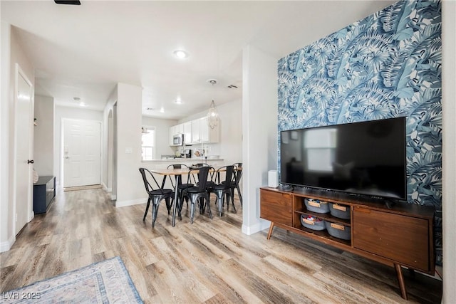 living room with light wood-style floors, baseboards, and recessed lighting
