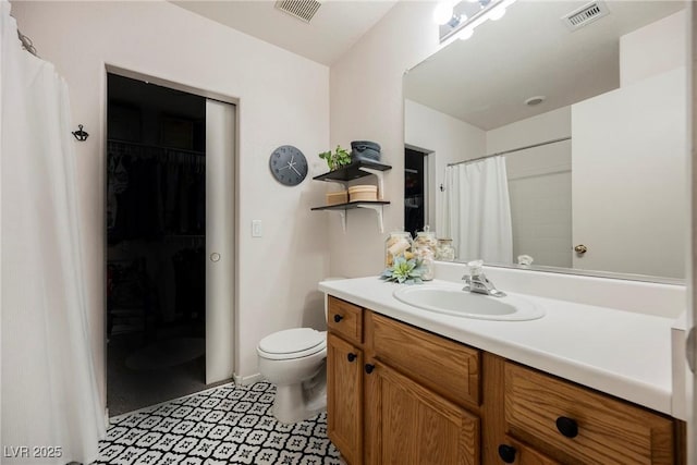 full bathroom featuring toilet, vanity, and a walk in closet
