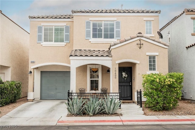 mediterranean / spanish-style home with an attached garage, covered porch, a tiled roof, and stucco siding