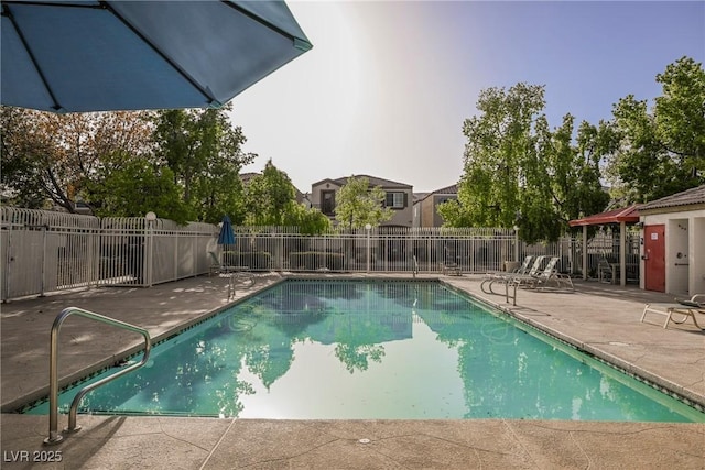 view of swimming pool with a patio area and fence