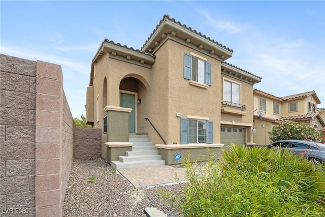 mediterranean / spanish-style home with stucco siding, a tile roof, and a garage