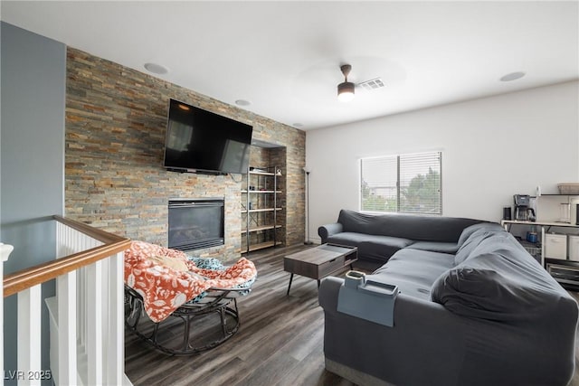living area with wood finished floors, a fireplace, and built in shelves