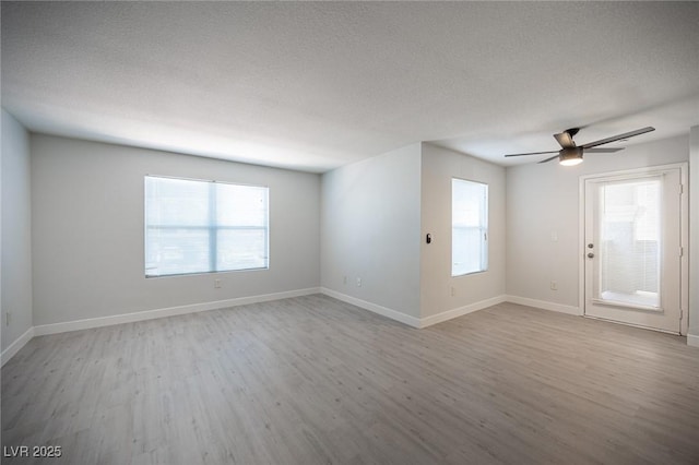 5055 W Hacienda Ave Unit 1097, Las Vegas, NV 89118 - empty room featuring wood finished floors, healthy amount of natural light, ceiling fan, baseboards, and a textured ceiling