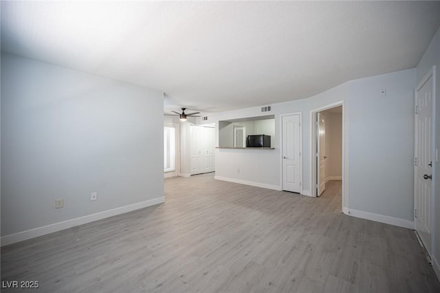 5055 W Hacienda Ave Unit 1097, Las Vegas, NV 89118 - unfurnished living room featuring ceiling fan, light wood-style flooring, and baseboards