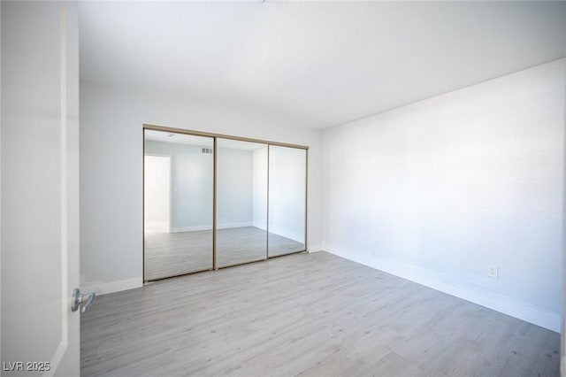 5055 W Hacienda Ave Unit 1097, Las Vegas, NV 89118 - unfurnished bedroom with wood finished floors, a closet, and baseboards