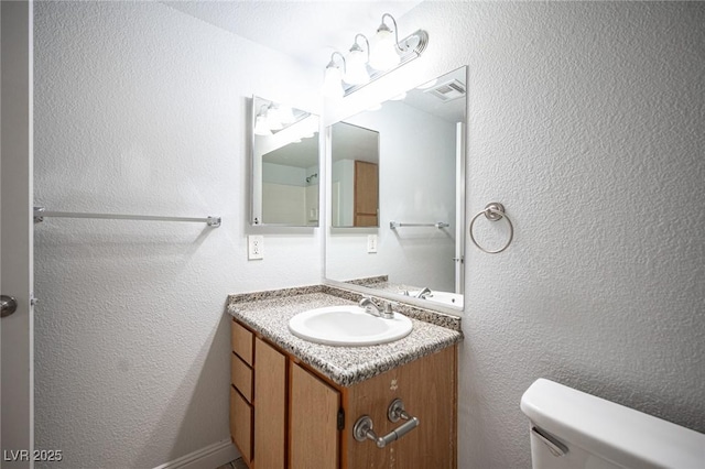 5055 W Hacienda Ave Unit 1097, Las Vegas, NV 89118 - half bathroom with toilet, a textured wall, and vanity
