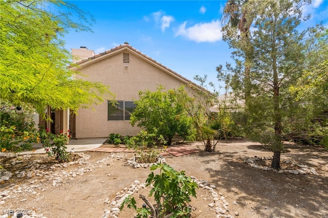 4517 Rodman Dr, Las Vegas, NV 89130 - rear view of property featuring stucco siding, a chimney, and a tile roof