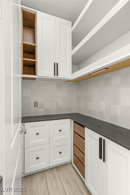 kitchen featuring open shelves, dark countertops, and white cabinetry