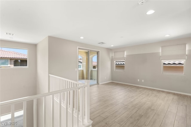 unfurnished room with light wood finished floors, recessed lighting, baseboards, and a smoke detector
