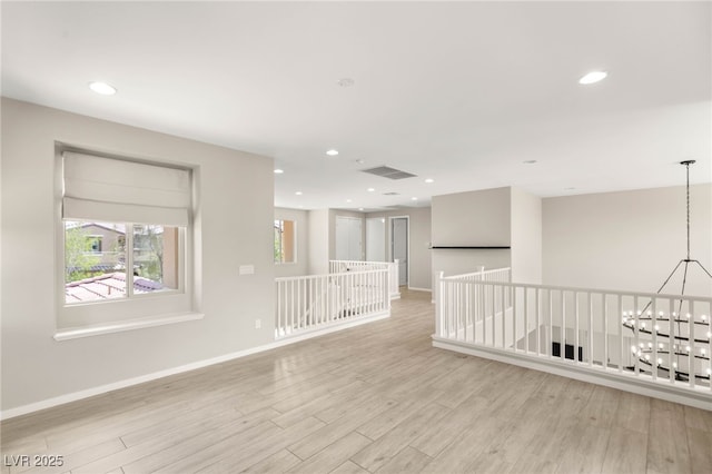 unfurnished room with light wood-type flooring, baseboards, and recessed lighting