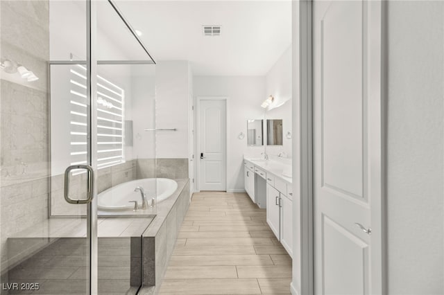 full bath with a garden tub, a stall shower, vanity, and wood finished floors