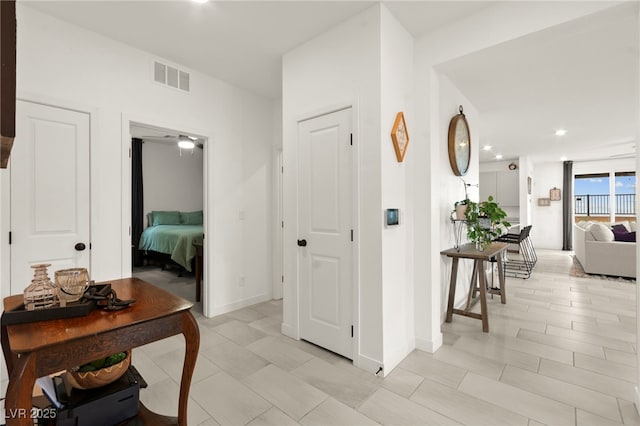 hallway with recessed lighting and baseboards