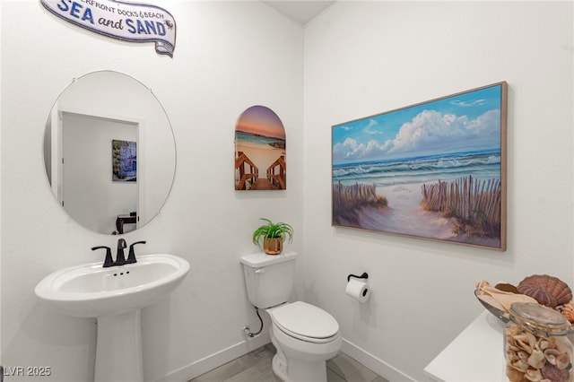 bathroom featuring baseboards and toilet