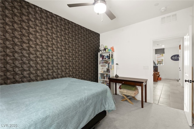 bedroom with wallpapered walls, an accent wall, carpet, and a ceiling fan