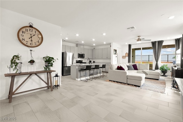 living room featuring ceiling fan and recessed lighting