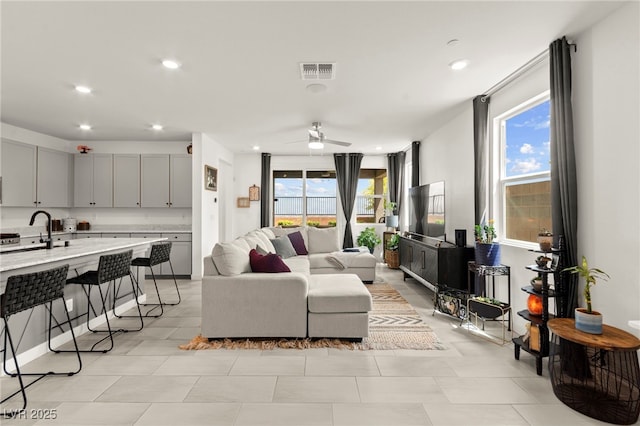 living area with a ceiling fan and recessed lighting