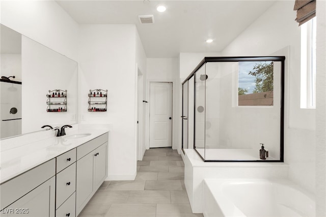 full bath with plenty of natural light, a shower stall, vanity, a garden tub, and recessed lighting
