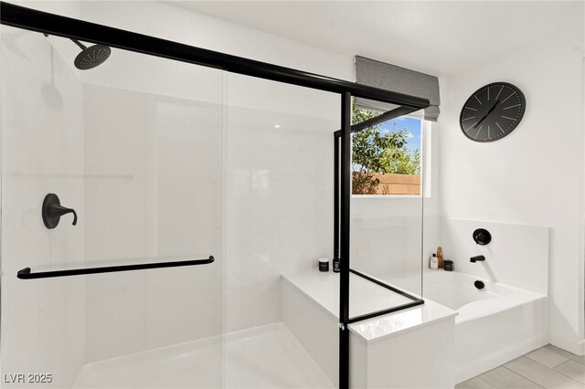 bathroom with an enclosed shower and a bath