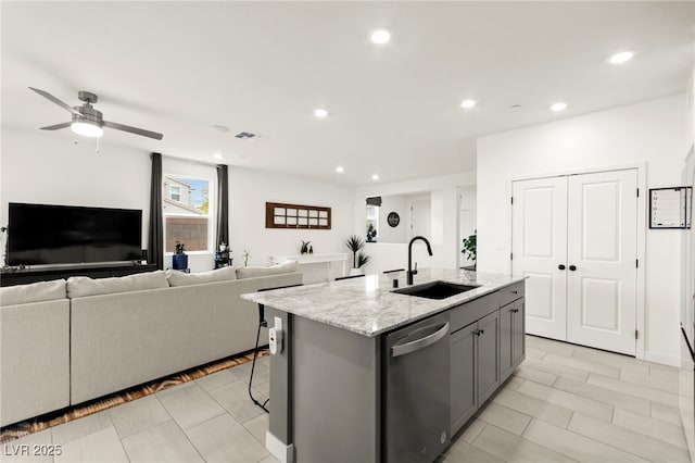 kitchen with stainless steel dishwasher, a sink, gray cabinets, open floor plan, and recessed lighting