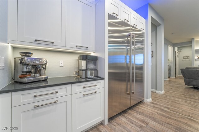 5865 Alice Landing Ct, Las Vegas, NV 89149 - kitchen with built in fridge, dark countertops, white cabinets, and light wood-style flooring