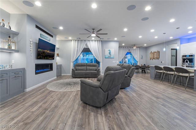5865 Alice Landing Ct, Las Vegas, NV 89149 - living room with wood finished floors, a ceiling fan, a glass covered fireplace, recessed lighting, and baseboards