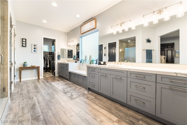 5865 Alice Landing Ct, Las Vegas, NV 89149 - bathroom featuring a shower stall, wood finished floors, vanity, recessed lighting, and a walk in closet