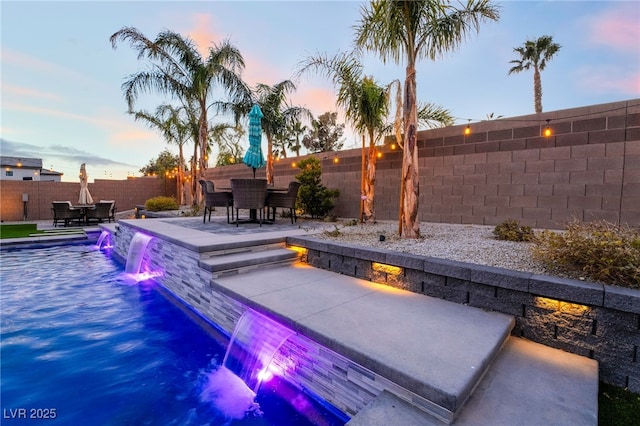 5865 Alice Landing Ct, Las Vegas, NV 89149 - pool at dusk featuring outdoor dining area, a patio, and a fenced backyard