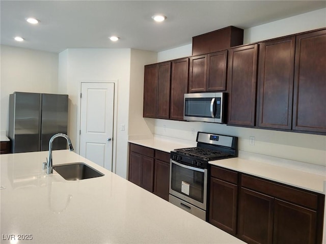 7672 Lush Oasis Ave, Las Vegas, NV 89113 - kitchen featuring appliances with stainless steel finishes, a sink, light countertops, dark brown cabinetry, and recessed lighting