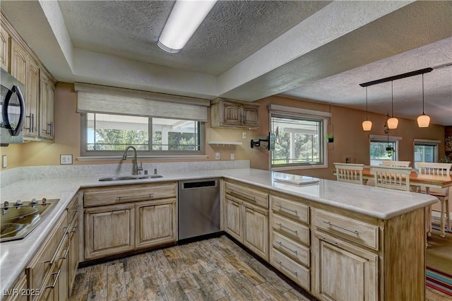 893 Fairway Dr, Boulder City, NV 89005 - kitchen with black appliances, a sink, a textured ceiling, a peninsula, and light brown cabinetry