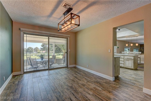 893 Fairway Dr, Boulder City, NV 89005 - empty room featuring wood finished floors, baseboards, a textured ceiling, and a chandelier