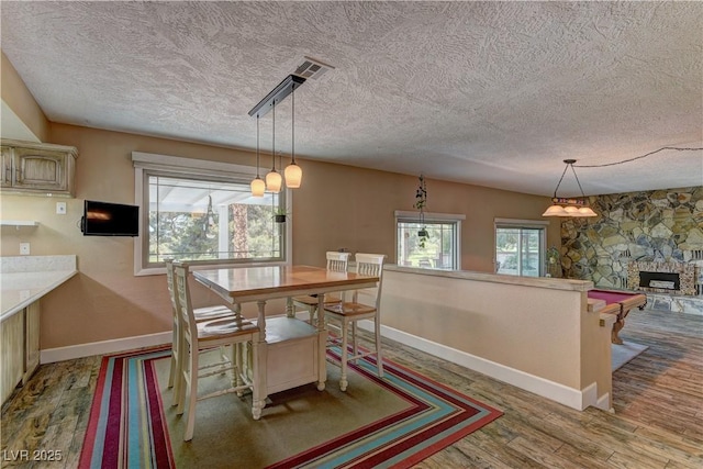 893 Fairway Dr, Boulder City, NV 89005 - dining space featuring a textured ceiling, baseboards, wood finished floors, and a fireplace