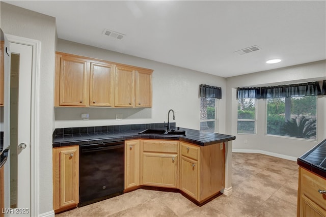 kitchen with black dishwasher, a sink, light brown cabinets, and a peninsula