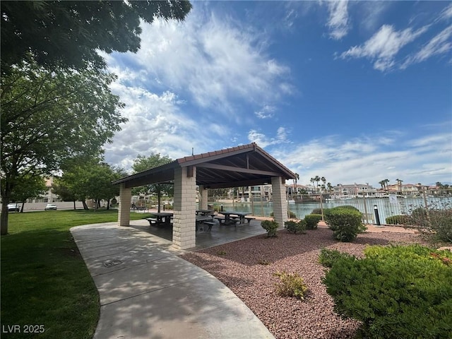 surrounding community with a lawn, a water view, and a gazebo
