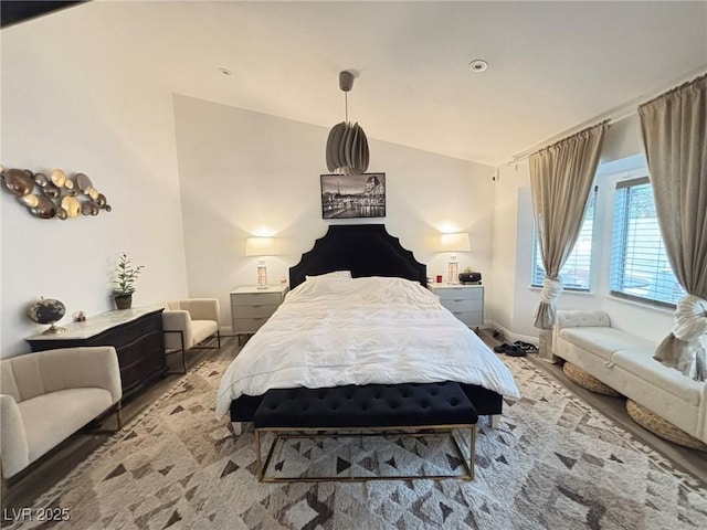 bedroom with wood finished floors and vaulted ceiling