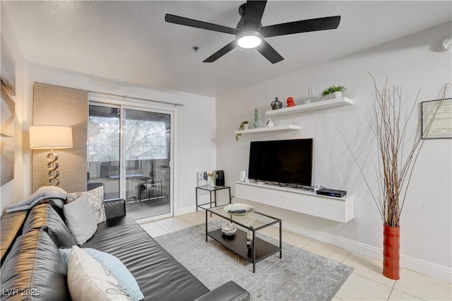 living area with ceiling fan, tile patterned flooring, and baseboards