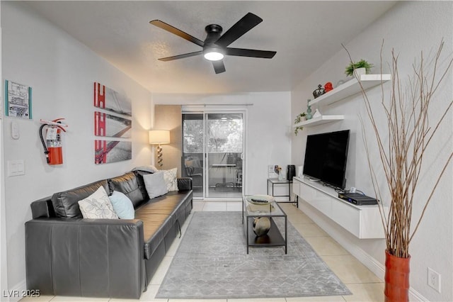 living area with light tile patterned floors and ceiling fan