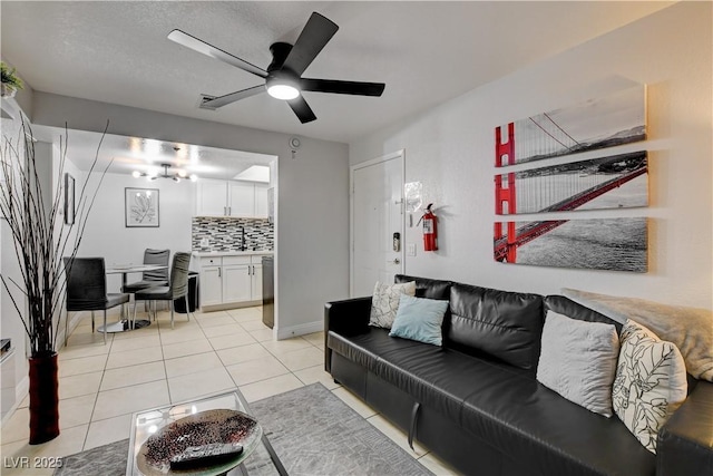 living room with a ceiling fan, light tile patterned floors, and baseboards