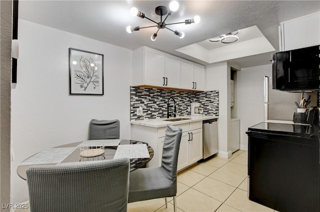 kitchen featuring dishwasher, a sink, light countertops, decorative backsplash, and white cabinets
