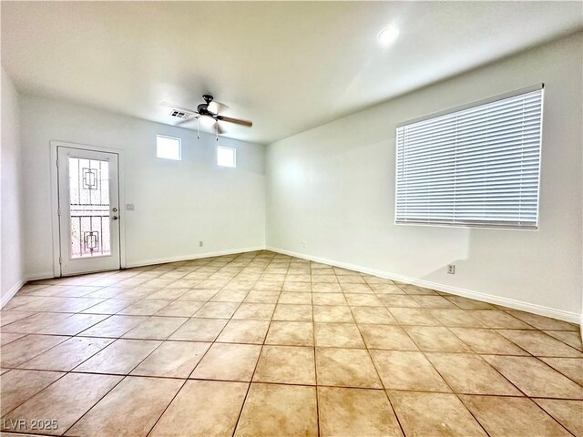 spare room with ceiling fan, light tile patterned floors, and baseboards