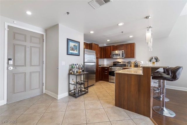 150 Las Vegas Blvd Unit 1608, Las Vegas, NV 89101 - kitchen featuring stainless steel appliances, a peninsula, a sink, baseboards, and a kitchen breakfast bar