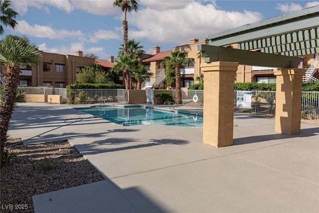 community pool with fence and a patio area