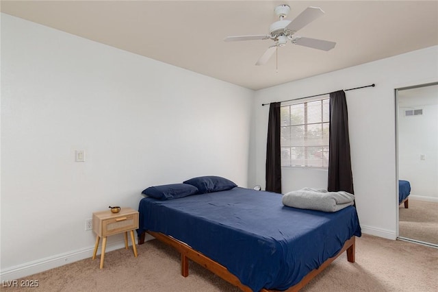 bedroom featuring light colored carpet, baseboards, and a ceiling fan