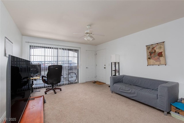 carpeted office space featuring a ceiling fan