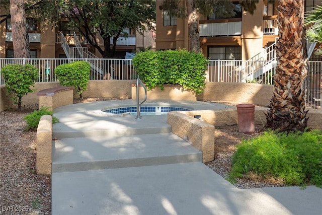 view of property's community featuring a hot tub and stairway