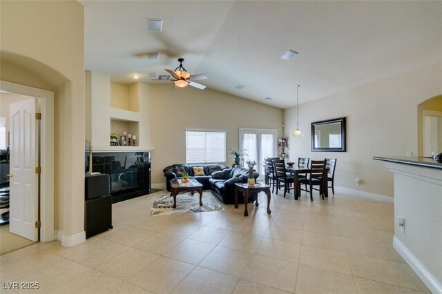 9524 Tyler Rose St, Las Vegas, NV 89178 - living room featuring a ceiling fan, light tile patterned floors, vaulted ceiling, baseboards, and arched walkways