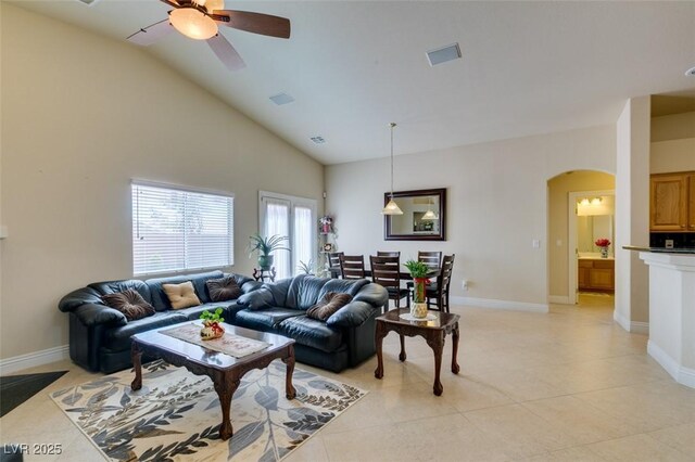 9524 Tyler Rose St, Las Vegas, NV 89178 - living room with arched walkways, ceiling fan, light tile patterned flooring, baseboards, and high vaulted ceiling