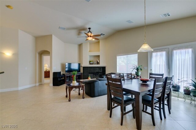 9524 Tyler Rose St, Las Vegas, NV 89178 - dining room with arched walkways, a ceiling fan, vaulted ceiling, baseboards, and a fireplace