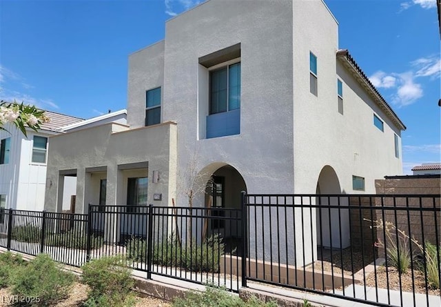 view of front facade with a fenced front yard and stucco siding
