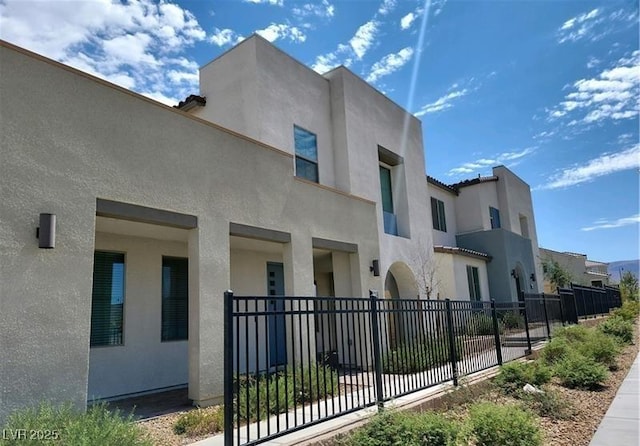 view of side of home with fence and stucco siding